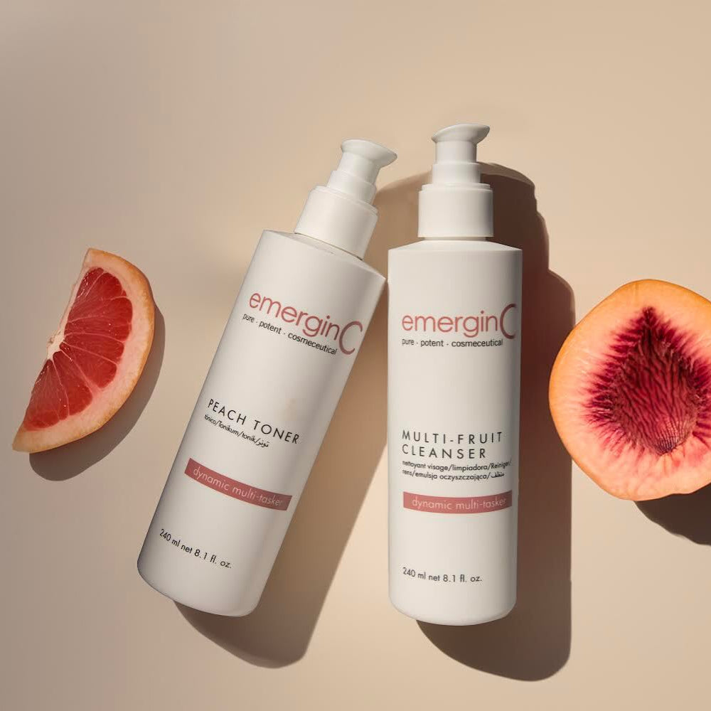 Bottle of peach toner with a slice of grapefruit on a neutral background