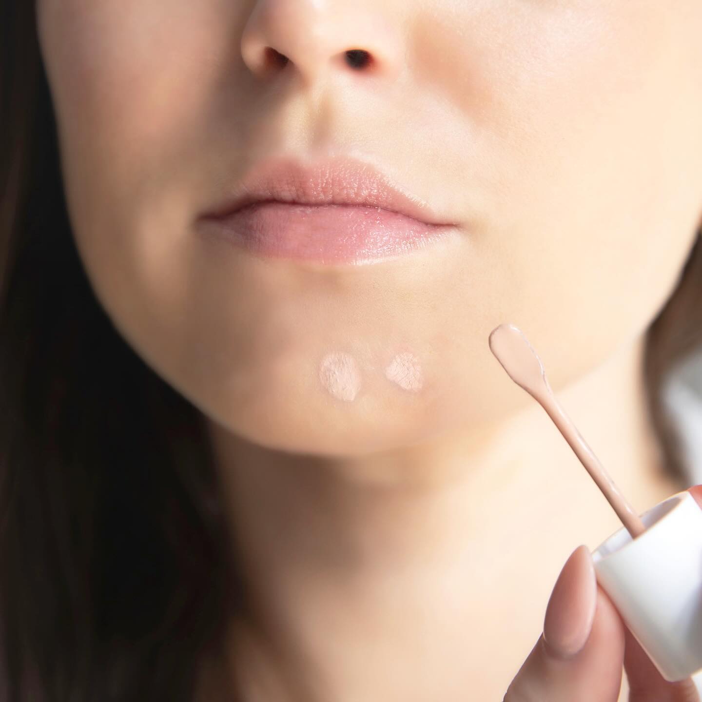 Applying emerginC Tinted Blemish Control to skin